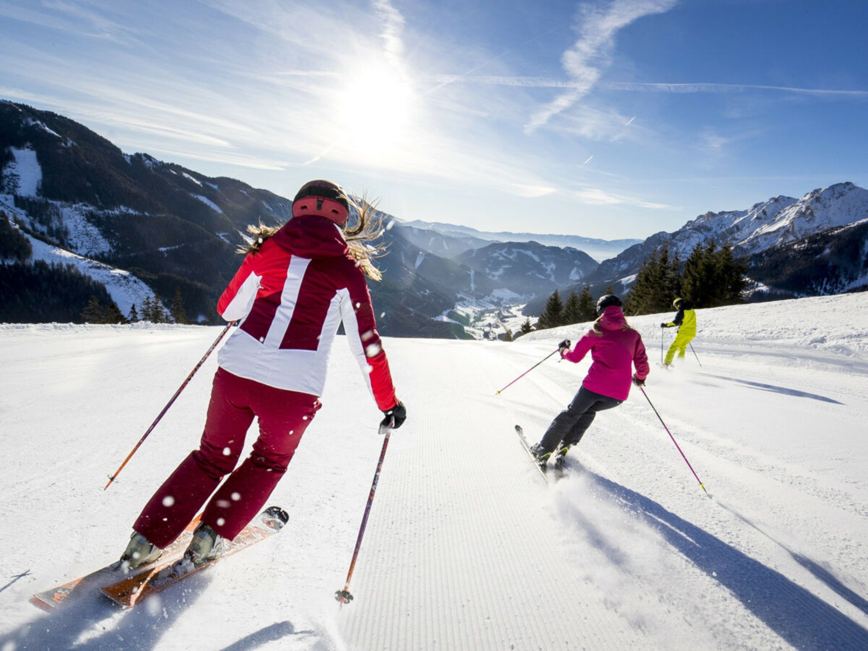 A snowy mountain landscape with skiers.