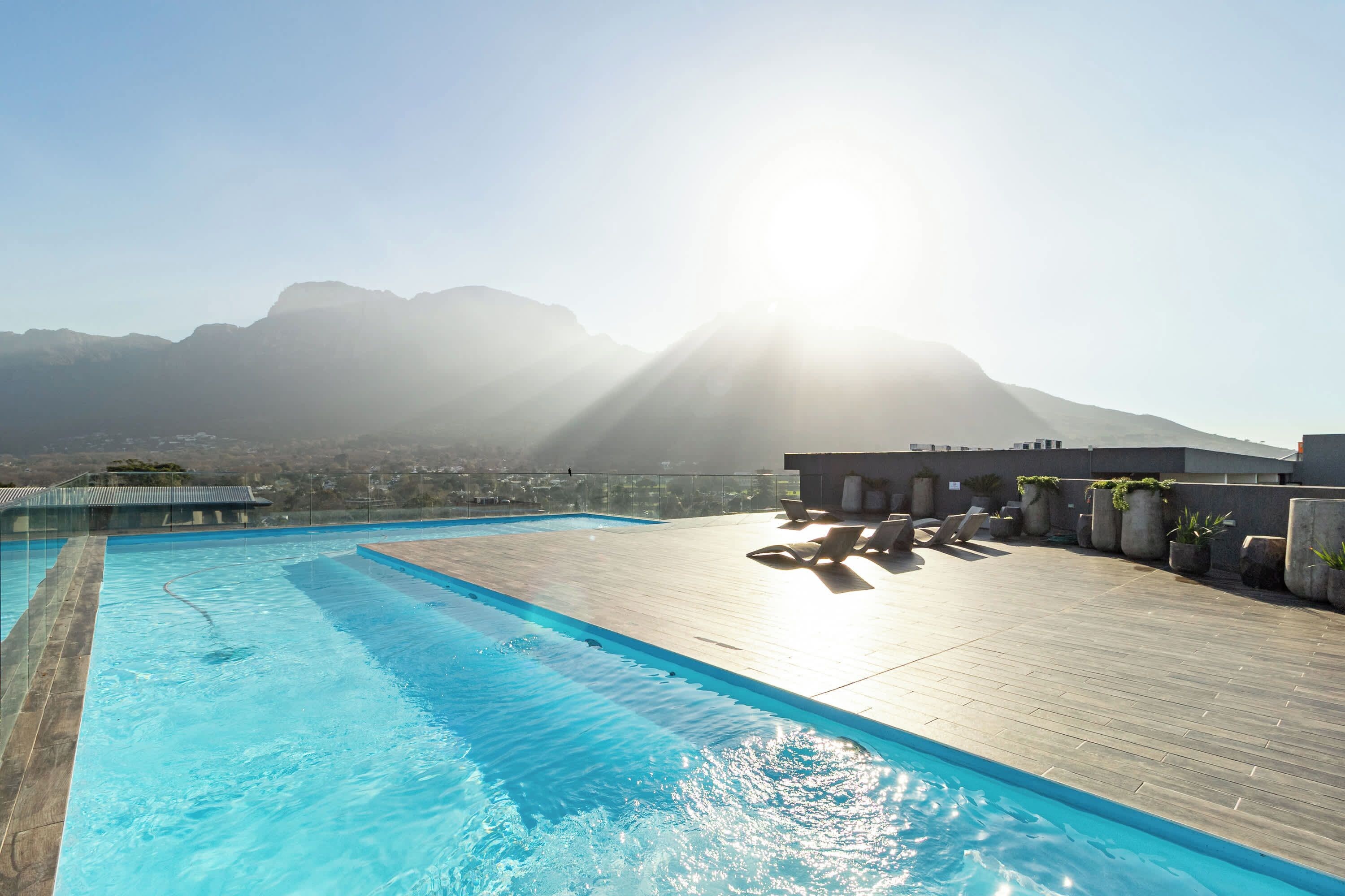Ein Pool auf dem Dach mit freiem Blick auf die Berge im Hintergrund.