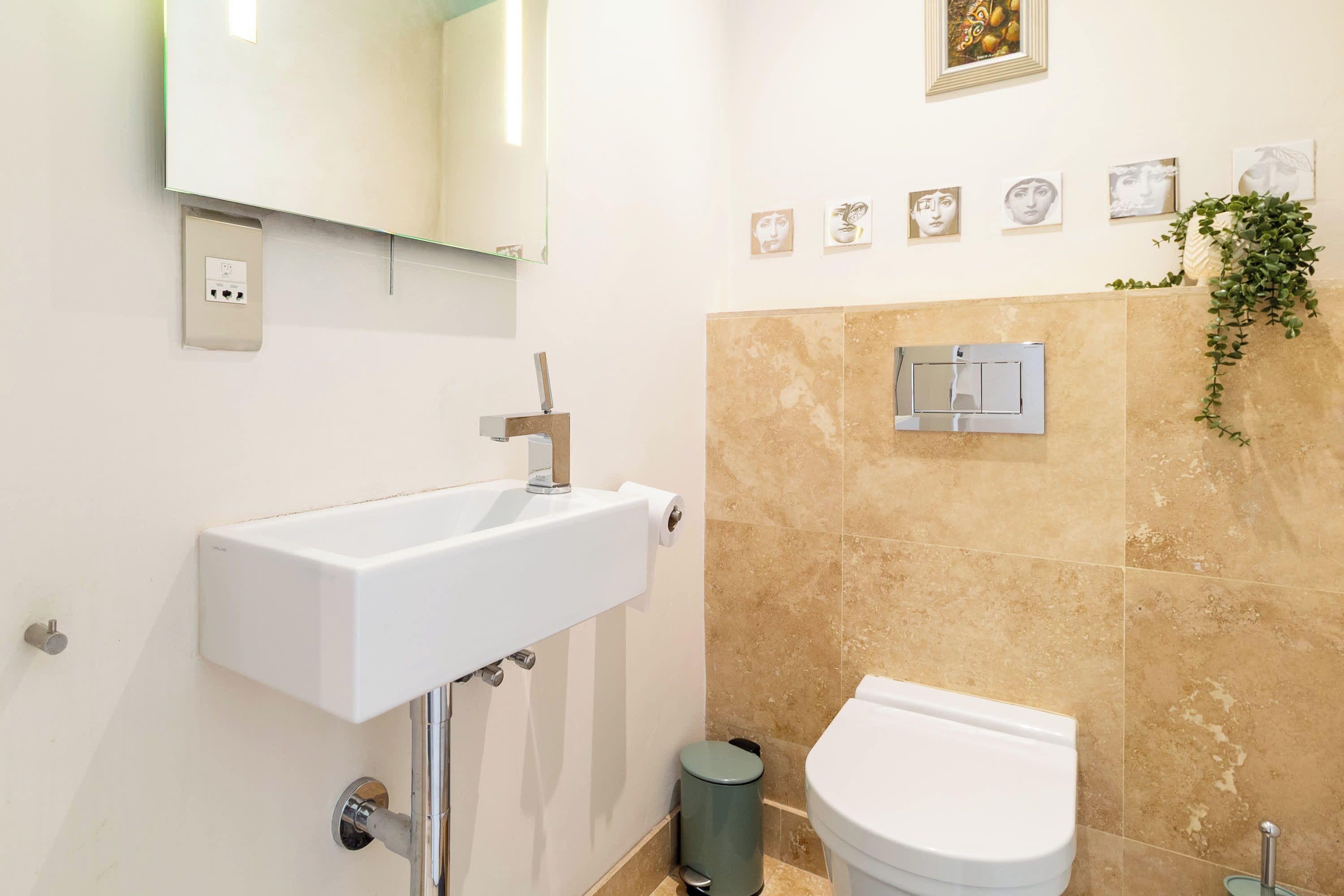 A modern bathroom with a white sink, a toilet, and a shower area.