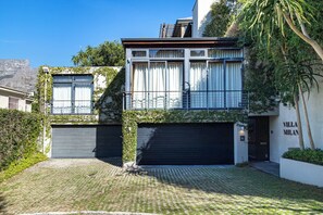 A modern villa with a two-story design, featuring a garage, a balcony, and a well-maintained garden. - Apartment Milano - Luxury Heritage Hideaway (Cape Town)