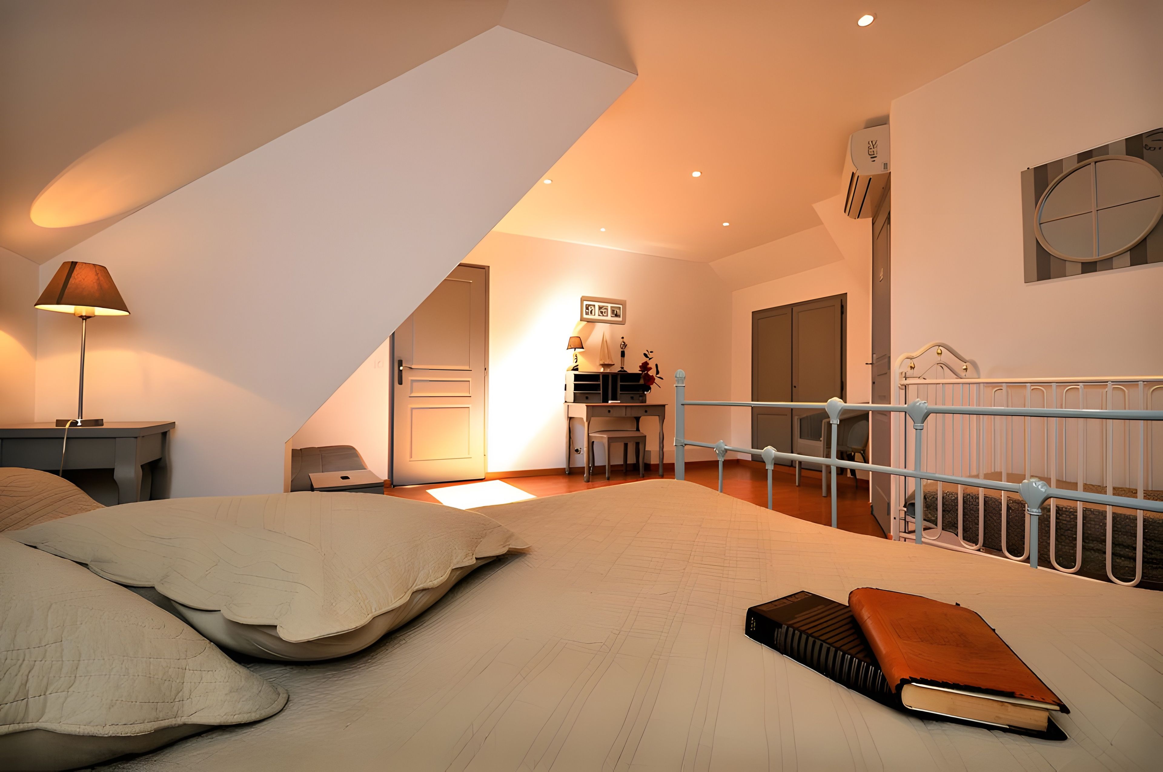 Une chambre à coucher comprenant un lit, une table de chevet, une lampe, un bureau et une chaise.