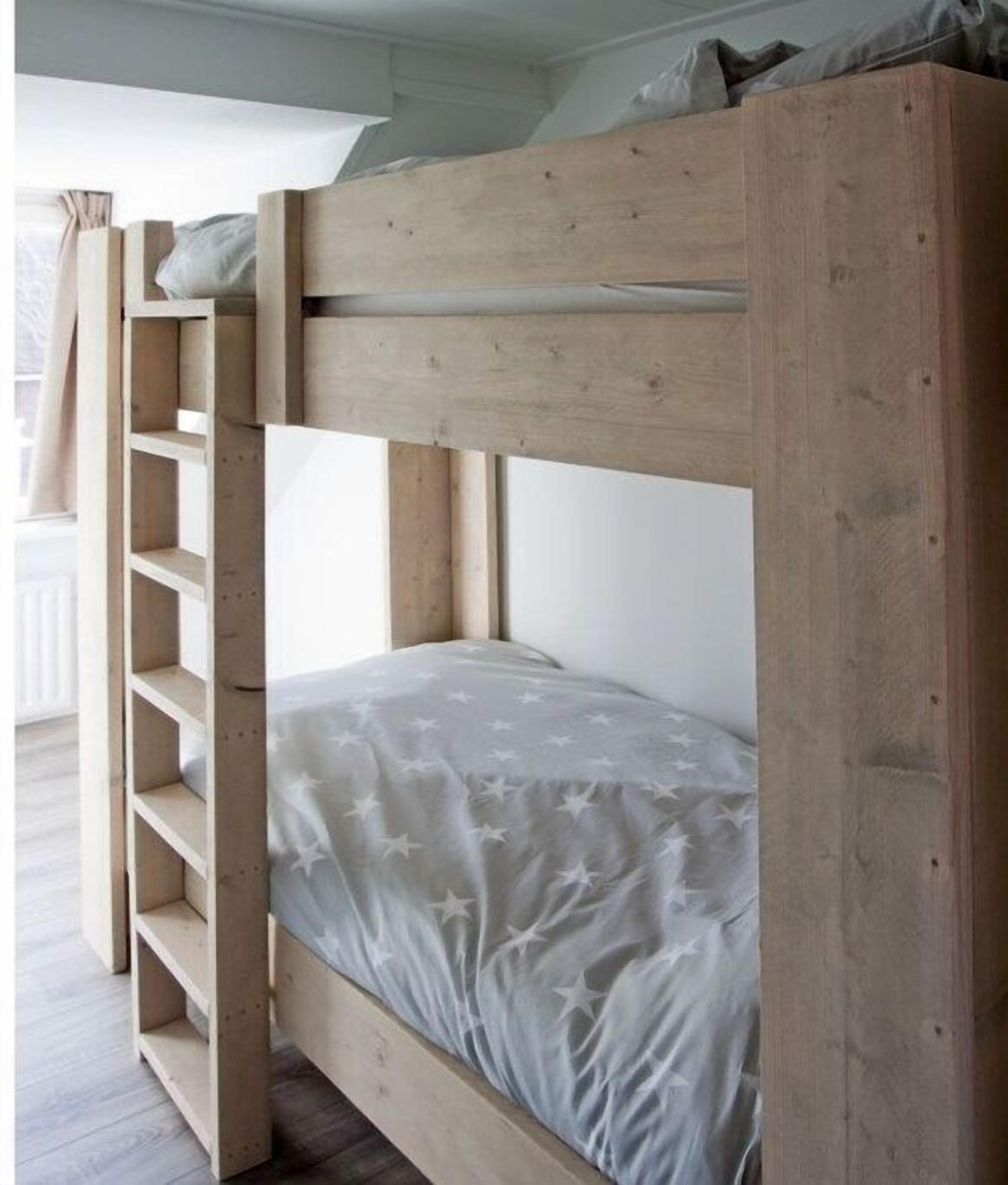 Una cama litera con estructura de madera y colcha gris con estampado de estrellas.