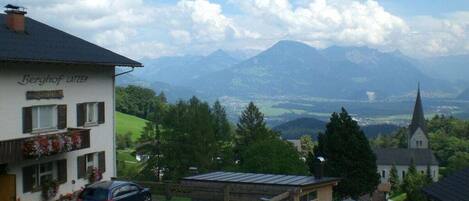 Ein Gebäude namens 'Berghof Latzier' mit Blick auf Berge und eine Kirche im Hintergrund.