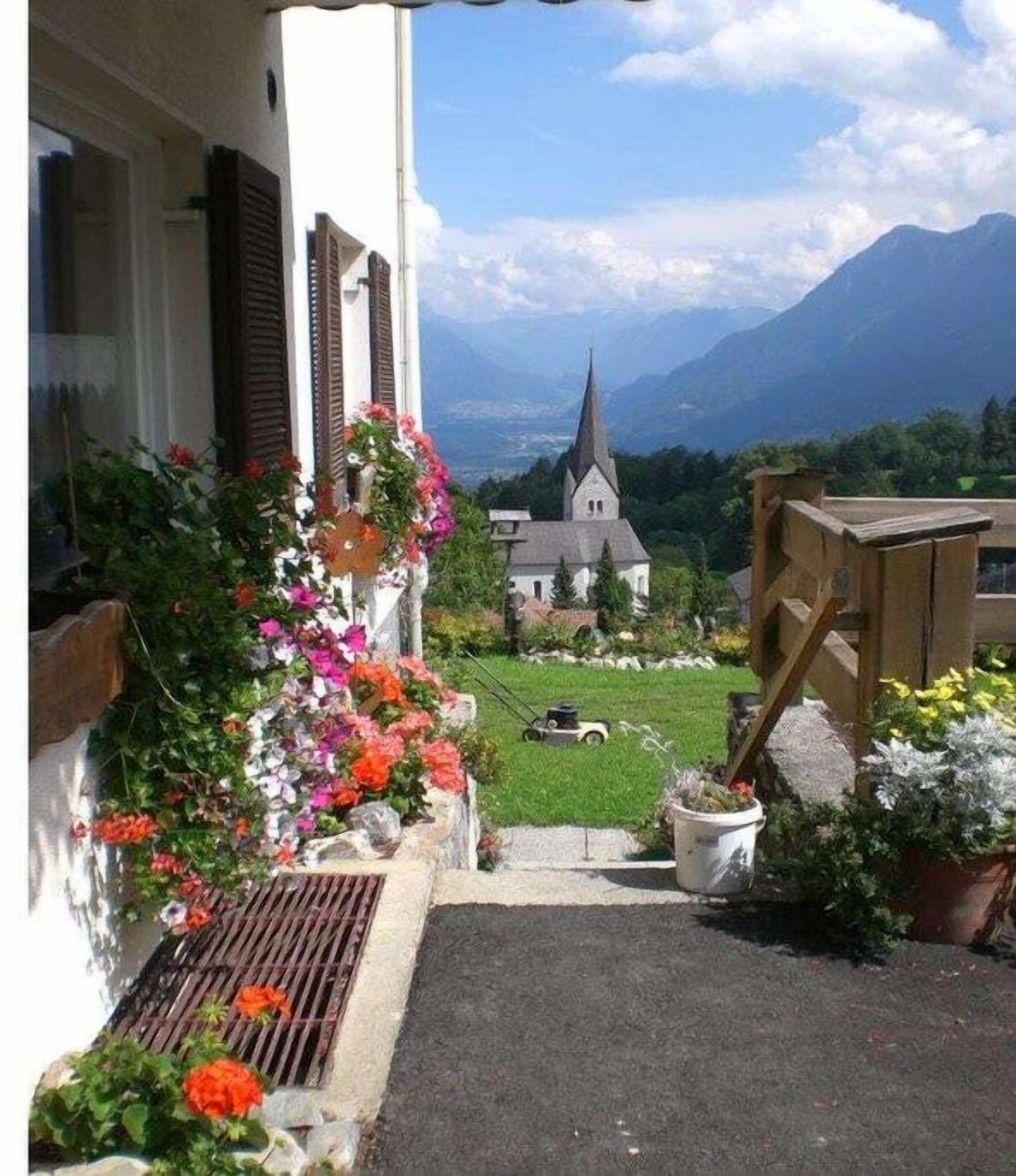 A pathway leading to a church with a mountain view.