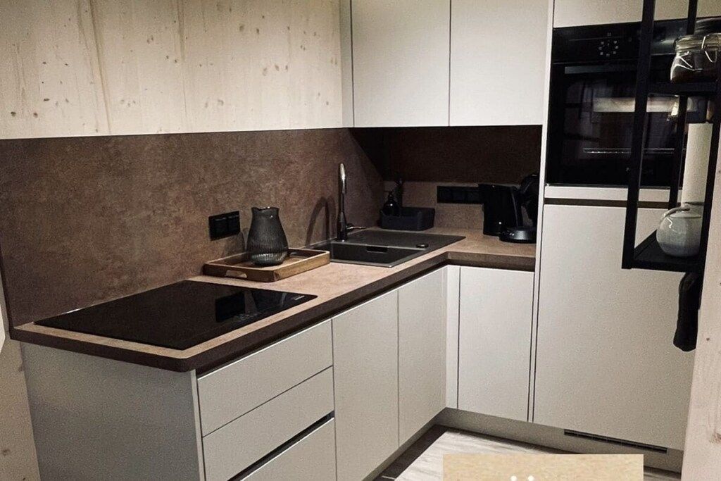 A modern kitchen with a built-in stove, a coffee maker, and a microwave.