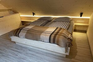 Ein Schlafzimmer mit einem Bett, zwei Nachttischen und Holzboden.