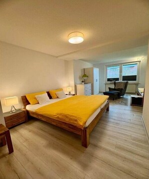 A bedroom with a large bed, bedside tables, a desk, and a chair. - Sea lavender in the house Sea greeting (Juist)