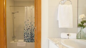 Une salle de bain avec une baignoire, une douche et un lavabo.
