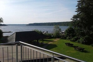 A lakeside view with a gazebo, picnic tables, and a boat dock. - Holiday apartment with 1 bedroom (Alt-Schwerin)