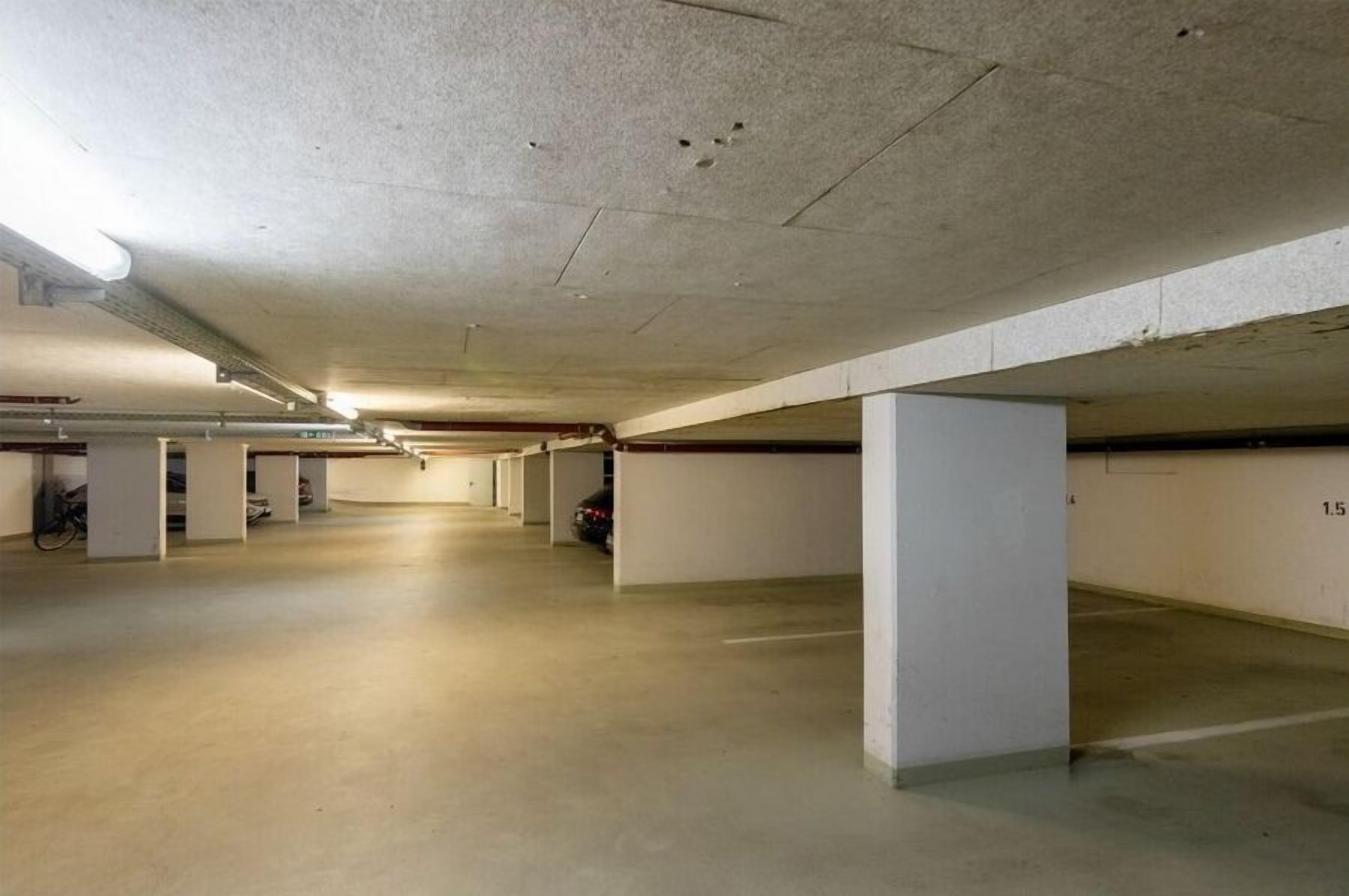 Eine mehrgeschossige Parkgarage mit Betonpfeilern und einer ebenen Fläche.
