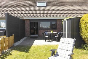 A residential property with a patio area, a brick exterior, and a fenced yard. - Holiday home with 2 bedrooms (Dornumersiel)