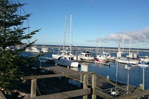 A marina with multiple boats docked, a wooden pier, and a clear sky. - Holiday home with 2 bedrooms (Kühlungsborn)