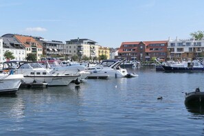 Een jachthaven met verschillende boten aanmeren, omringd door meerlaagsgebouwen met balkons.
