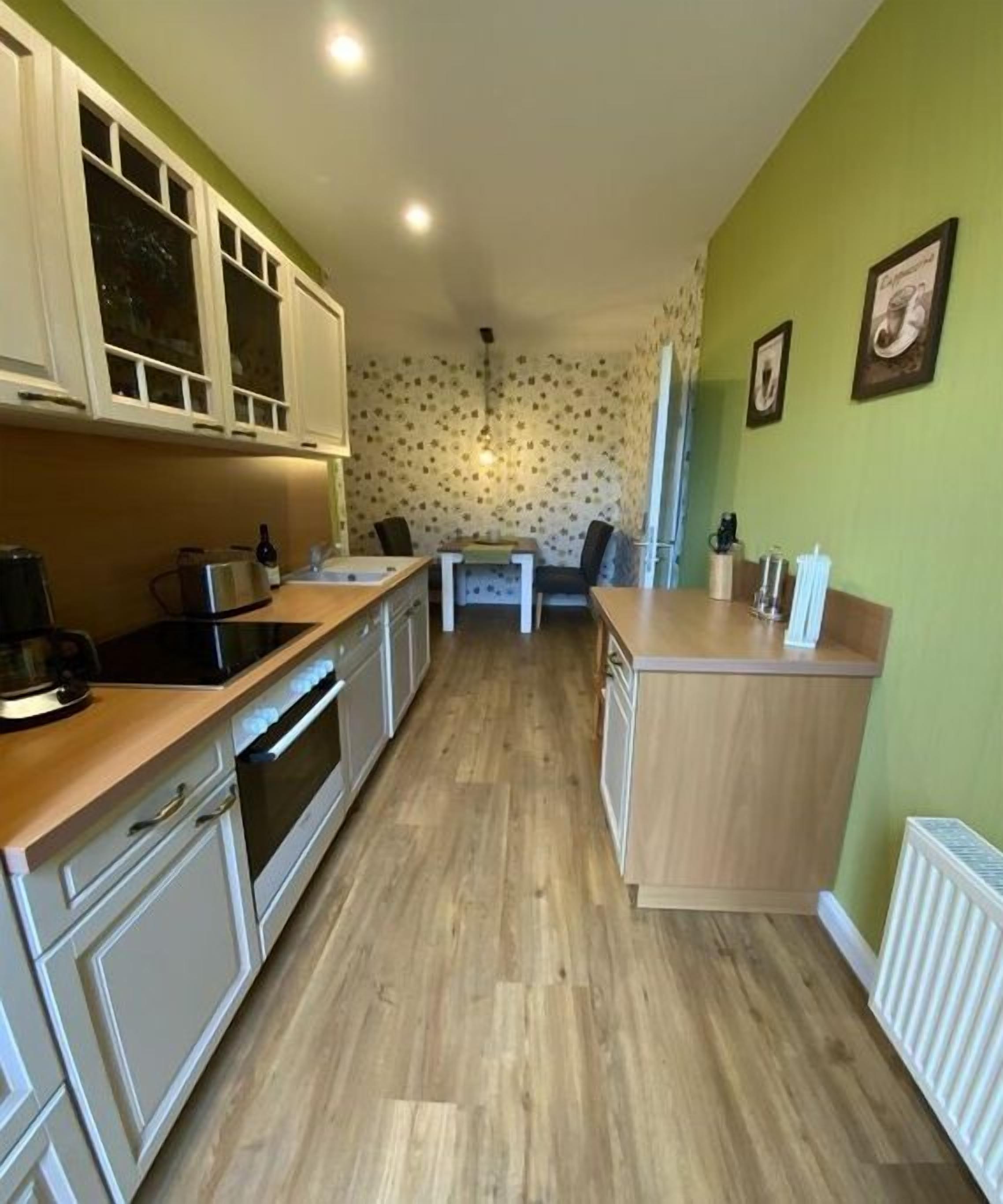 Una cocina con armarios de madera, una encimera y una zona de comedor con una mesa y sillas.