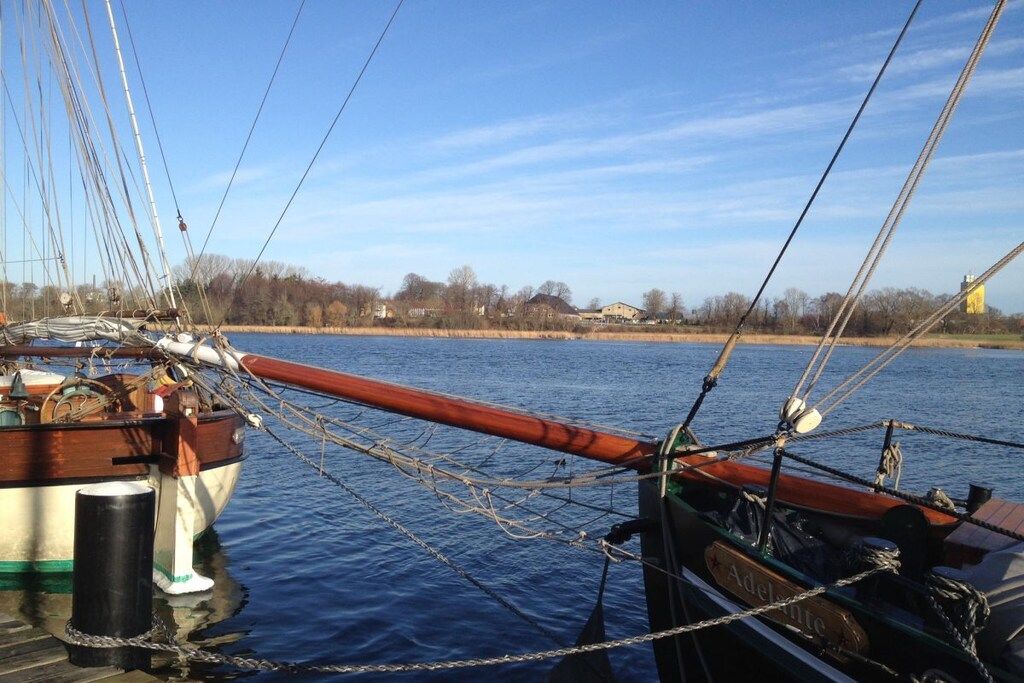 Un barco amarrado en un muelle con un cuerpo de agua tranquilo al fondo.
