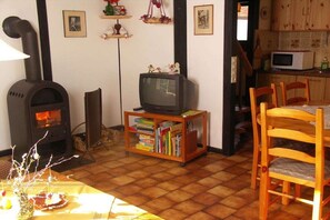 Ein gemütliches Wohnzimmer mit Kamin, Fernseher und Bücherregal.