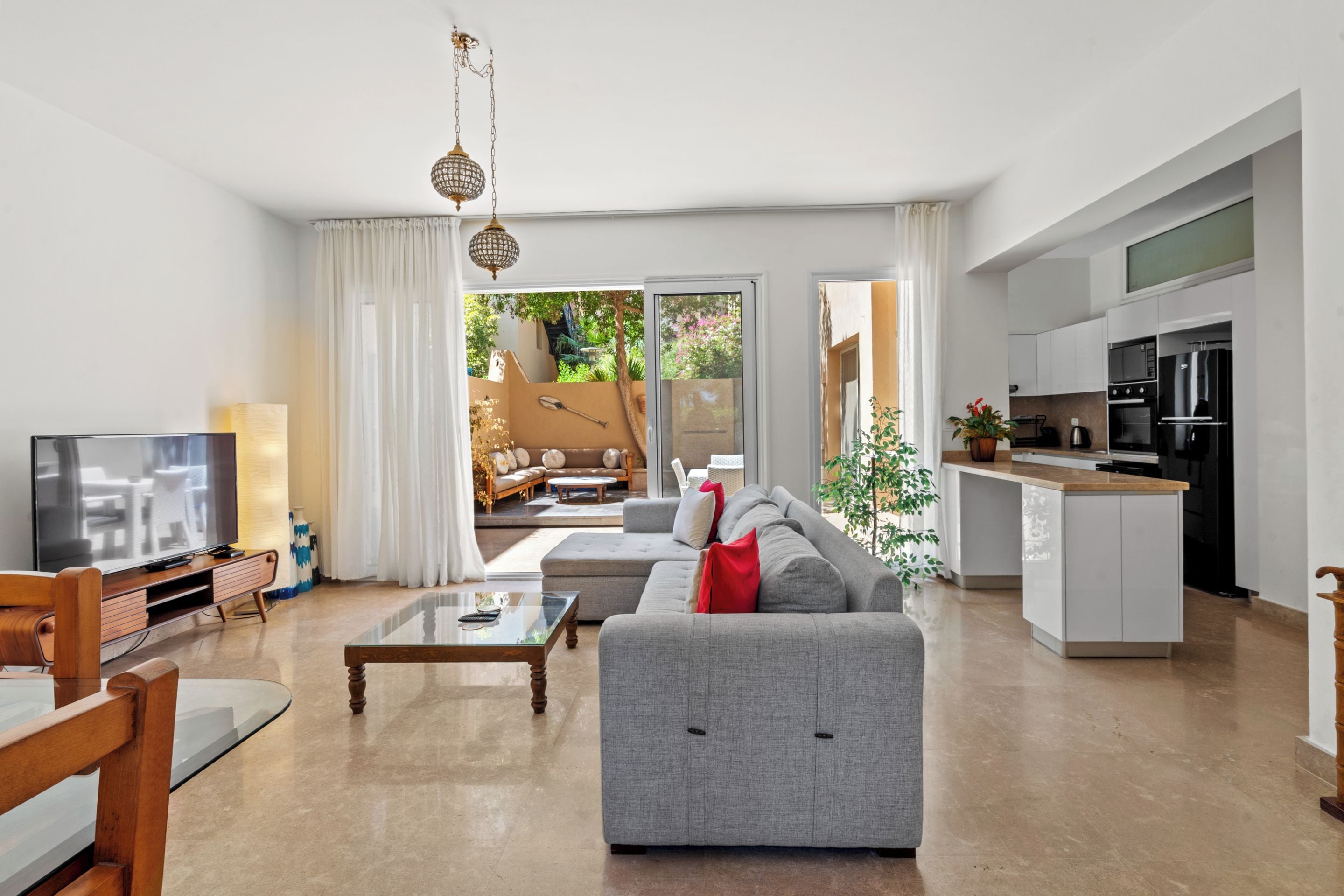 A modern living room with a grey sofa, a coffee table, and a television.