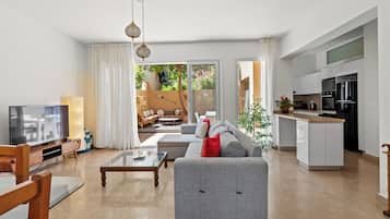 A modern living room with a grey sofa, a coffee table, and a television.