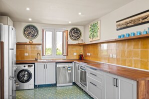 A modern kitchen with a washing machine, dishwasher, and a stove. - New Marina View Apartment El Gouna (El Gouna)