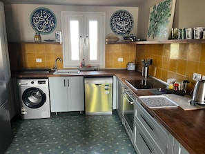 A kitchen with a washing machine, dishwasher, oven, and a sink. - Modern Apartment with Marina View (El Gouna)