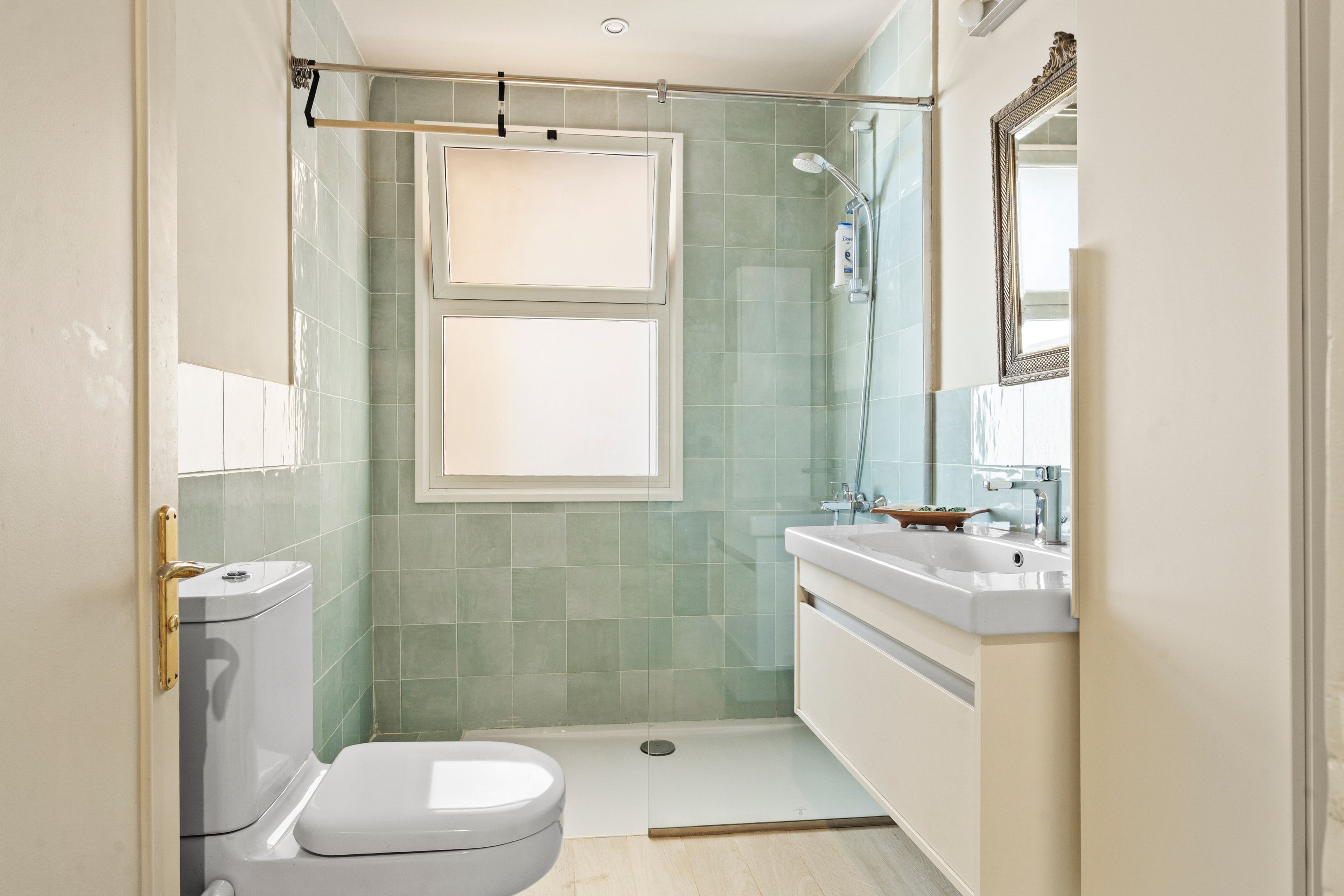 A bathroom with a toilet, a shower, and a sink.