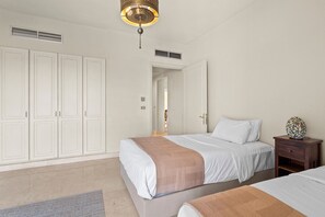 Un dormitorio con cama, mesita de noche, armario y lámpara colgante.