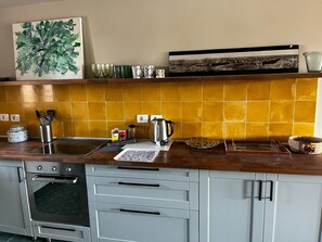 A kitchen with a stove, oven, and various kitchen items on the counter. - Modern Apartment with Marina View (El Gouna)