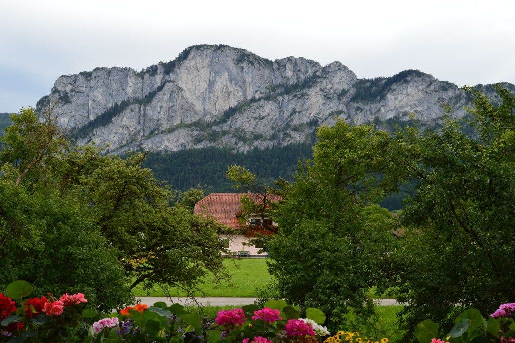 A mountain landscape with a building in the foreground.