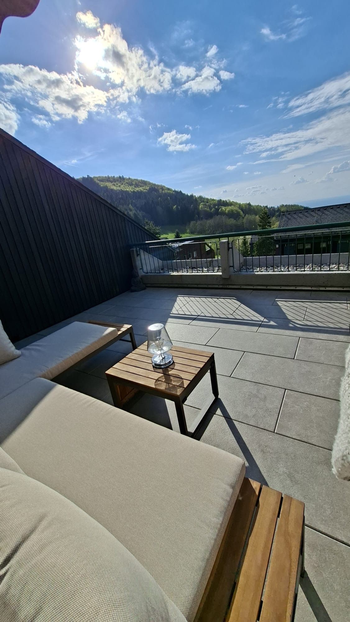 Un espace extérieur aménagé avec une table et des chaises, offrant une vue sur le paysage environnant et un ciel dégagé.