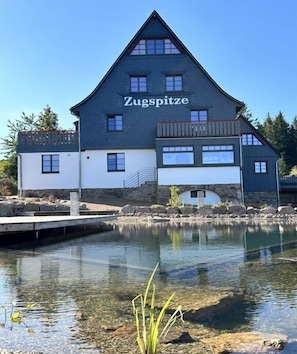 A building with a sign reading 'Zugspitze' near a body of water.