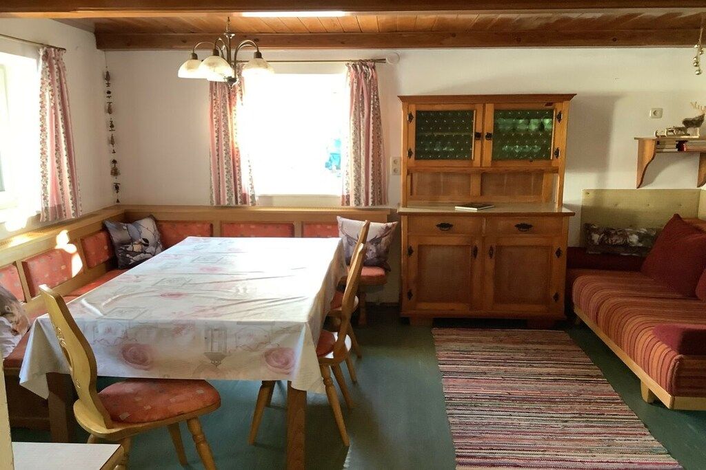Ein Essbereich mit Tisch, Stühlen und einem Holzschrank.