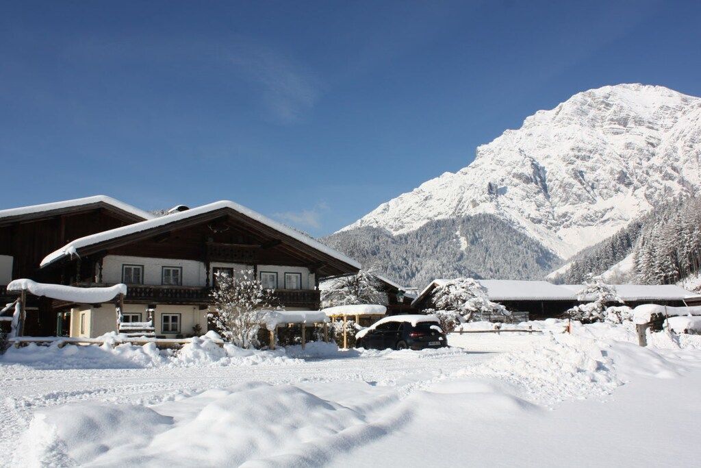 A snow-covered mountain lodge with a wooden exterior and multiple windows.