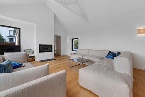 Un salon moderne avec un canapé, une table basse et un téléviseur.