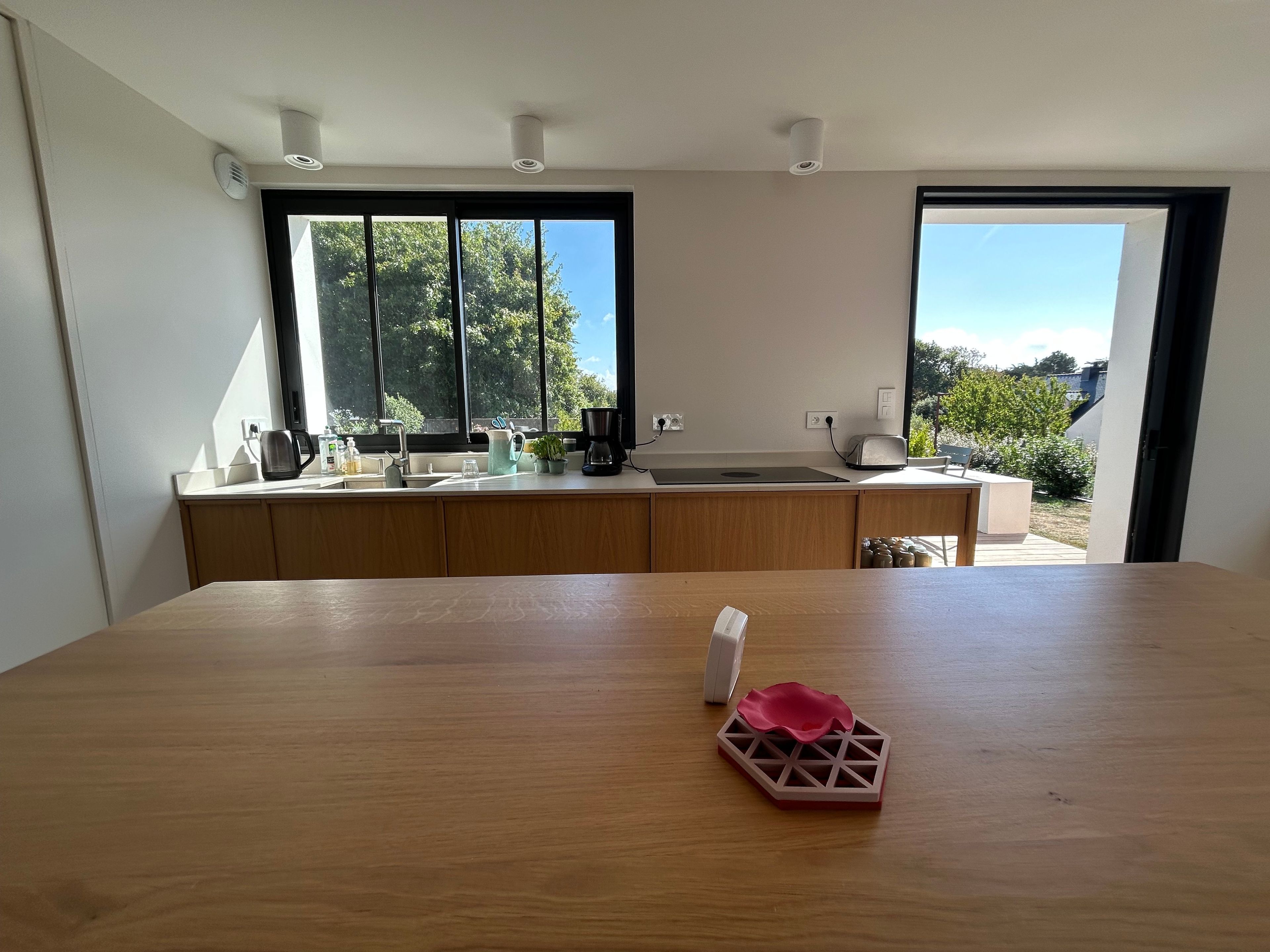 Eine moderne Küche mit Holzarbeitsplatte, Spüle und Fenster mit Blick auf einen Garten.