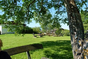 Ein grasbewachsenes Gelände mit einer Bank und einem Baum.