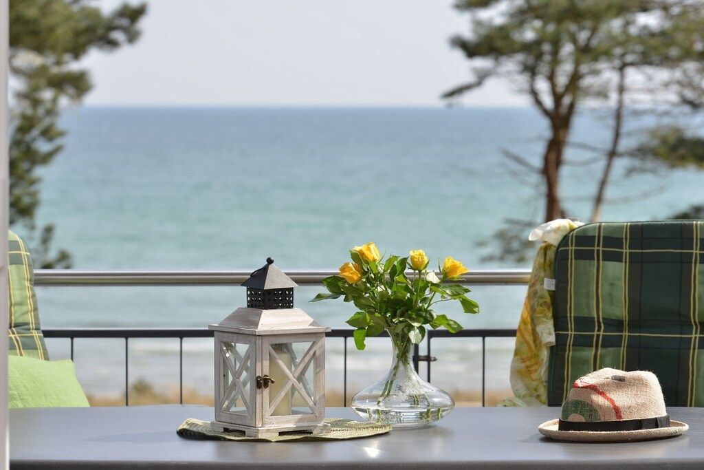 Ein Tisch mit einer Laterne, einer Vase mit gelben Blumen und einem Hut.