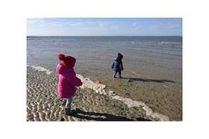 Two children playing on a beach with the sea in the background. - Holiday apartment with 2 bedrooms (Utersum auf Föhr)