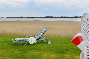 Two lounge chairs with a checkered pattern, one with a white towel, and a white and red object in the foreground. - Holiday home with 3 bedrooms (Breege\/ Juliusruh OT Breege)