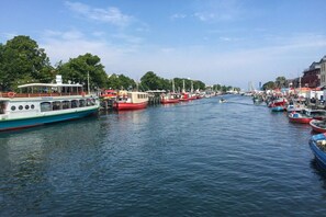 A marina with various boats docked along the waterway, surrounded by buildings and trees. - Holiday apartment with 1 bedroom (Bastorf OT Hohen Niendorf)