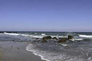 A beach with waves, rocks, and a pier. - Holiday apartment in Bad Doberan with balcony (Bad Doberan)