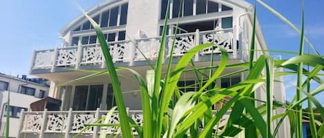 A multi-story building with balconies, surrounded by greenery.