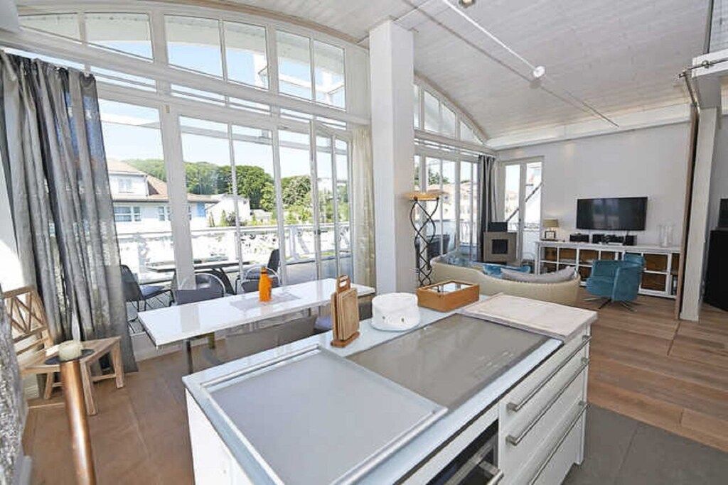 Een ruime kamer met een grote eettafel, een bank en een televisie.