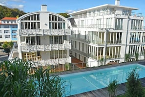 A two-story building with a swimming pool in front. - Holiday apartment with 1 bedroom (Sellin auf Rügen)