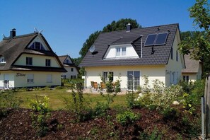Ein Wohngebiet mit zwei Häusern, eines mit dem Namen 'Stine' und das andere mit Solaranlage auf dem Dach.