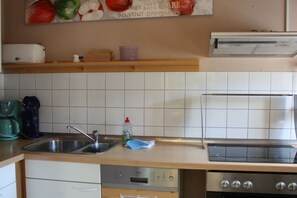 A kitchen with a built-in dishwasher, a stove, and a sink. - Holiday apartment with 2 bedrooms (Zinnowitz)