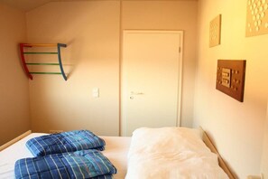 A bedroom with a bed, a door, and a wall-mounted rack. - Holiday apartment with 2 bedrooms (Zinnowitz)