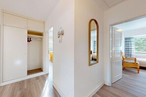 Una habitación con armario, espejo y cama con vistas al exterior.