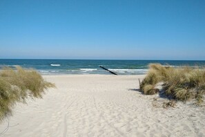 A sandy beach with a clear sky and ocean waves. - Holiday apartment with 1 bedroom (Zingst)