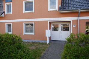 A residential building with a white door, windows, and a number '68' on the wall. - Holiday apartment with 1 bedroom (Zingst)