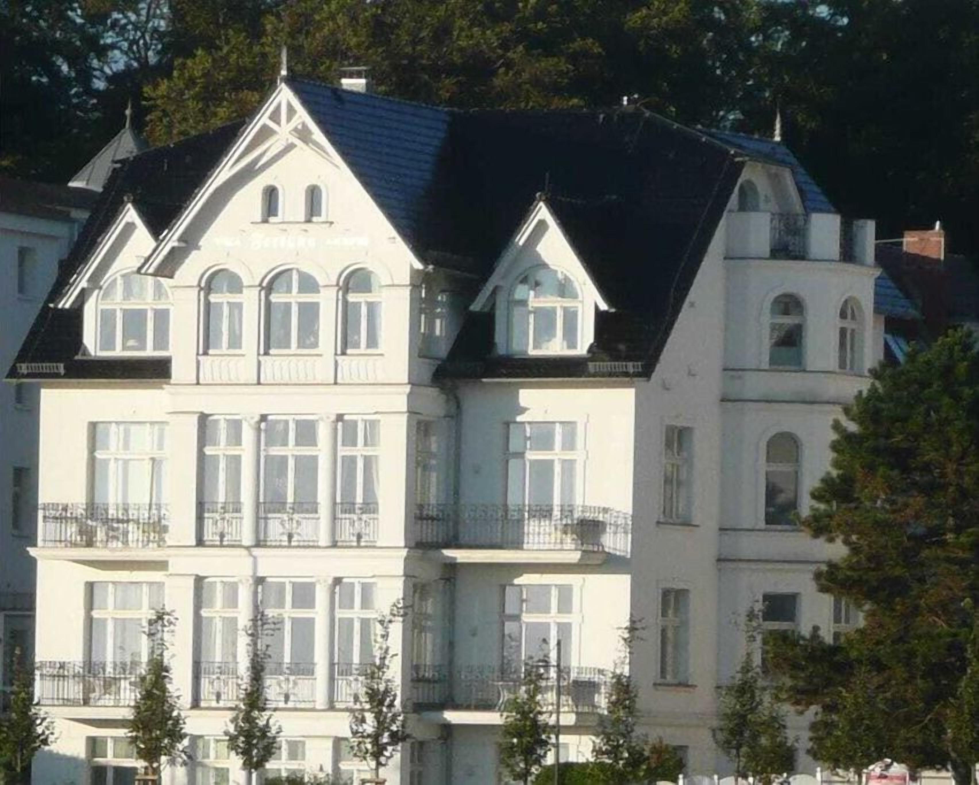 A multi-story building with a symmetrical facade, large windows, and balconies.